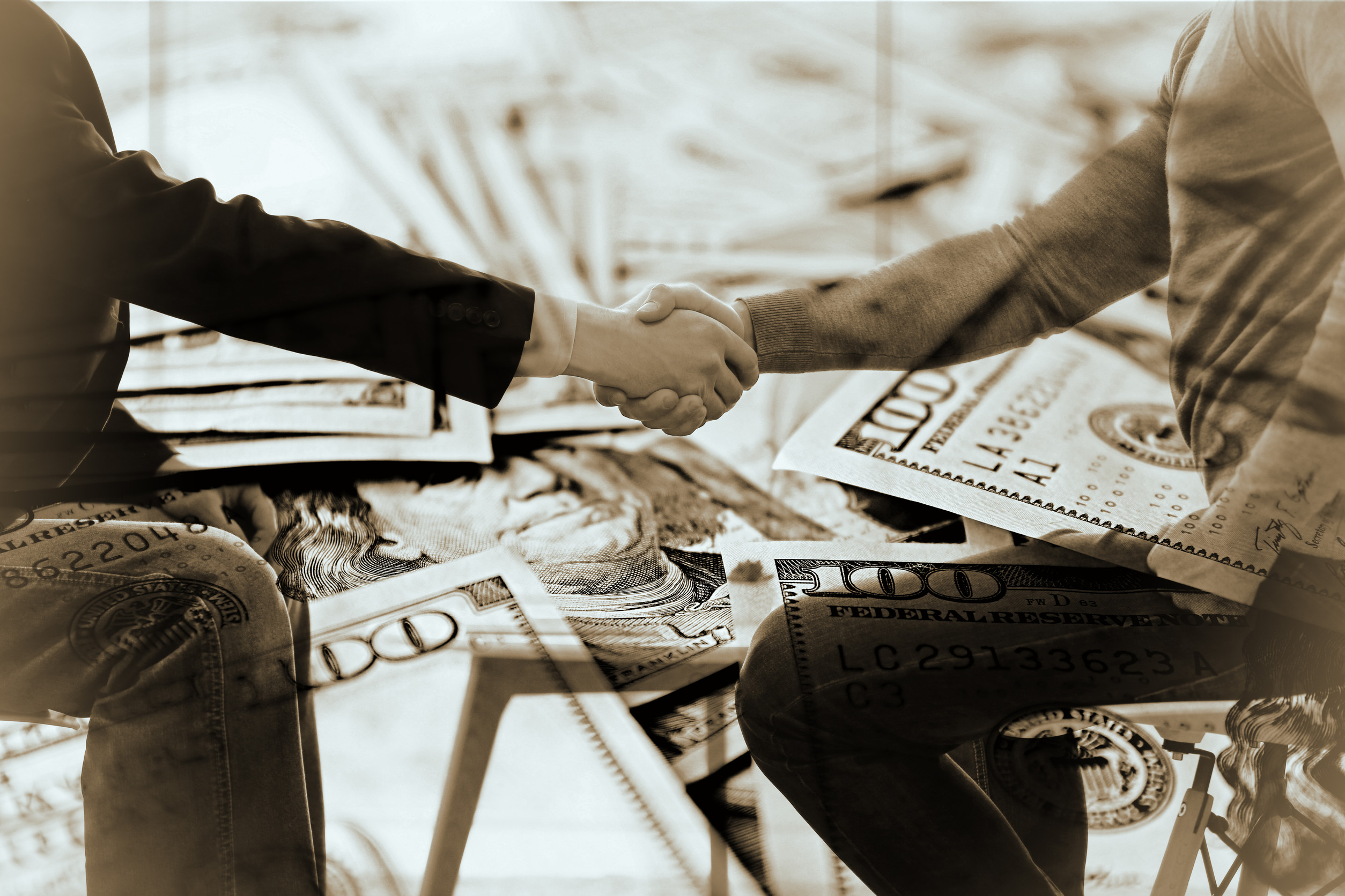 Business handshake on dollars background