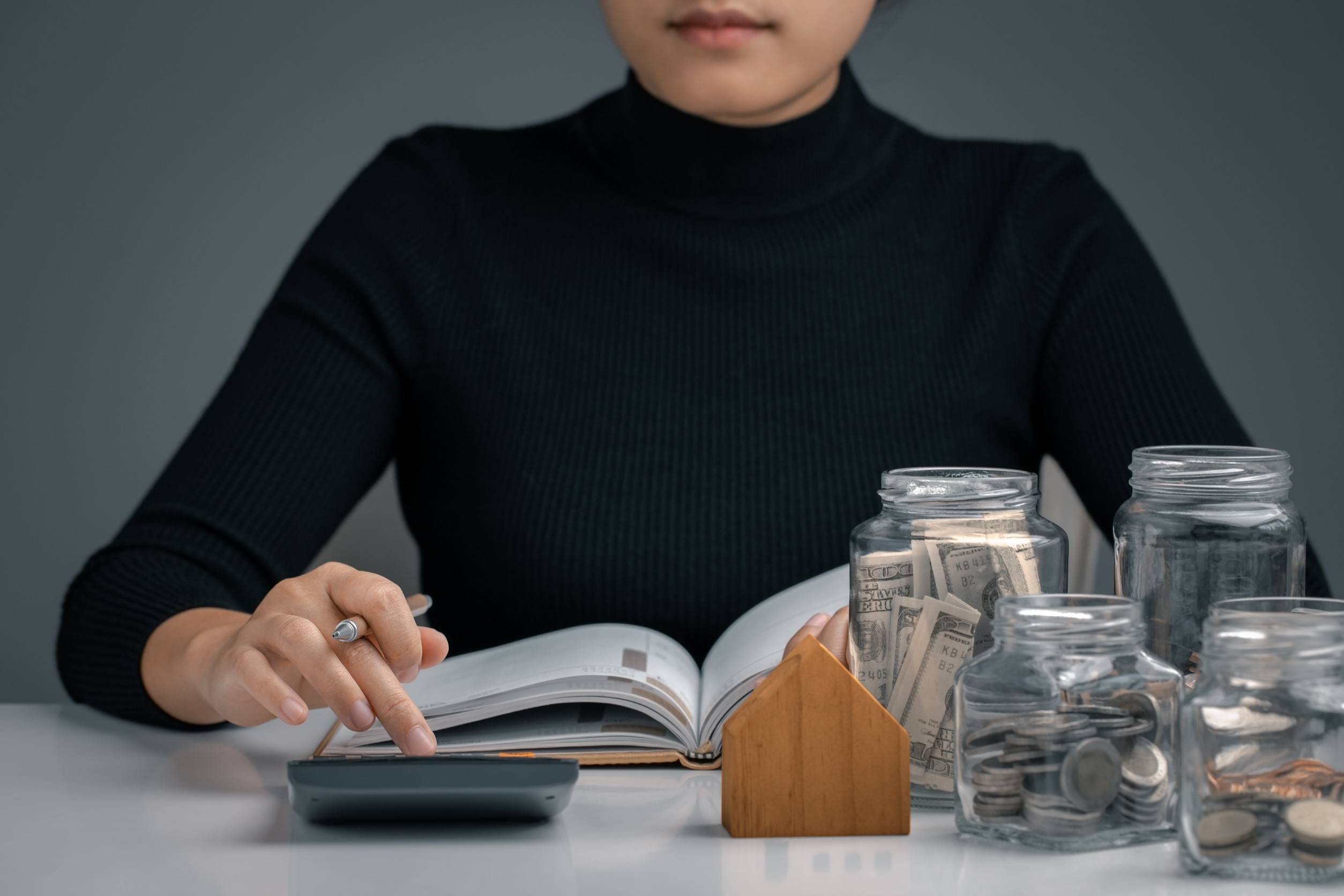Woman using a calculator and writing make note with business stu