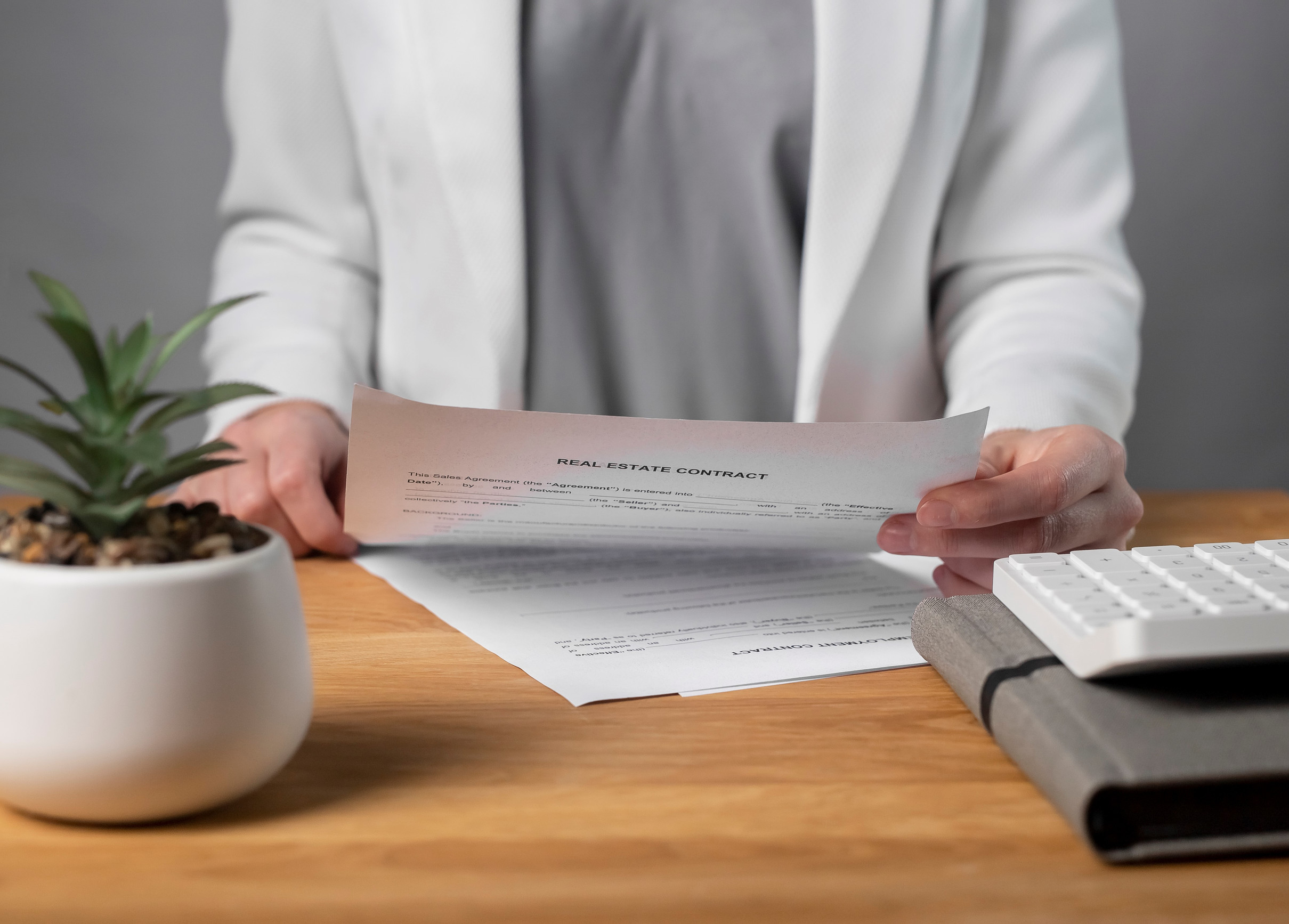 Businesswoman hand with real estate contract, reading and studying it at office desk