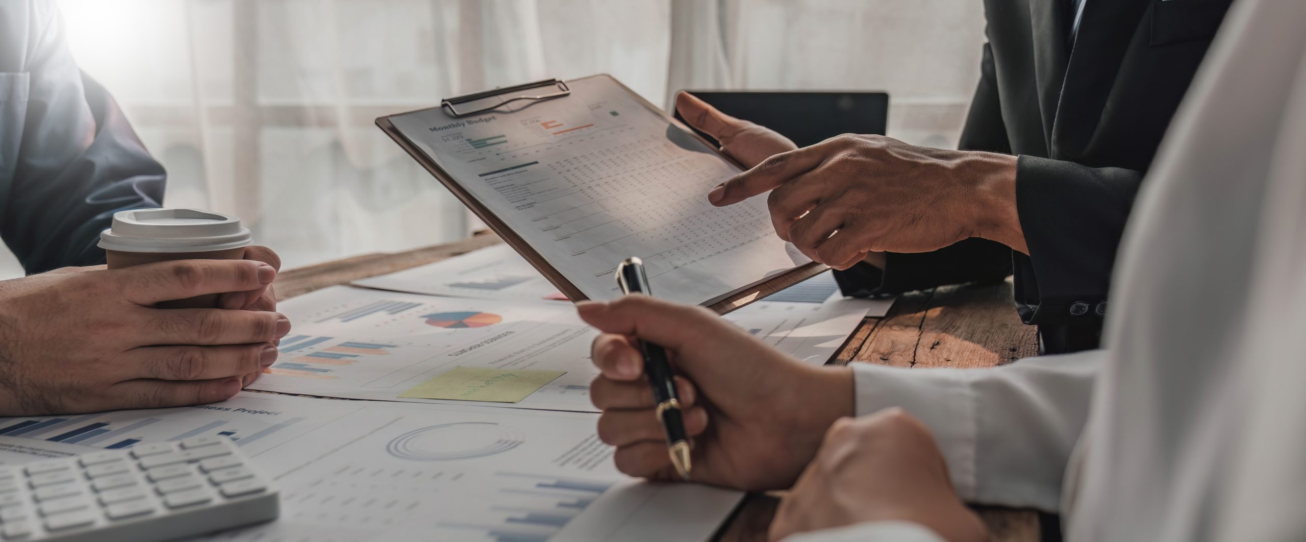 Business People Meeting using laptop computer,calculator,notebook,stock market chart paper for analysis Plans to improve quality next month Conference Discussion Corporate Concept