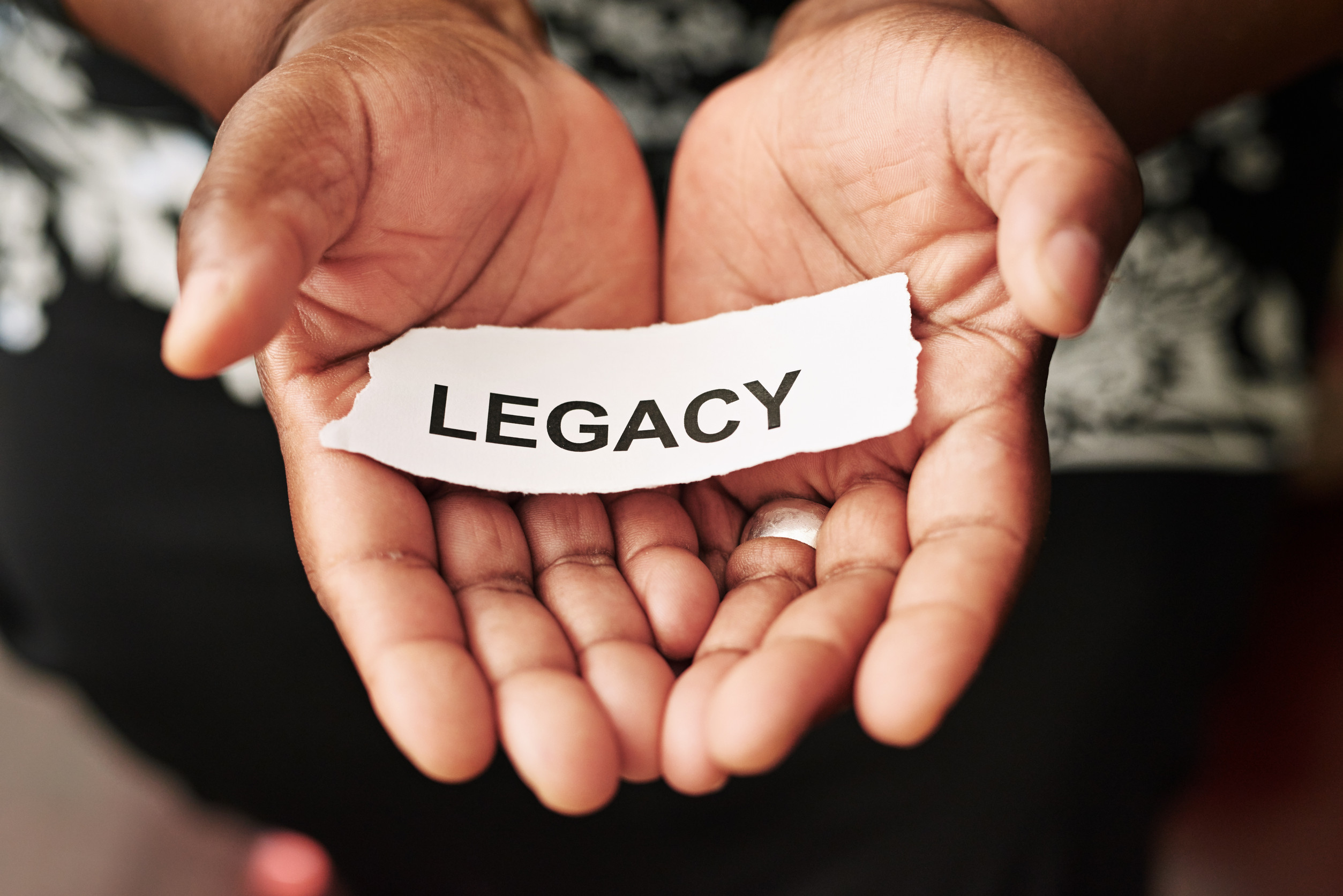 How do you want to be remembered Cropped shot of a woman holding a piece of paper with the word legacy on it