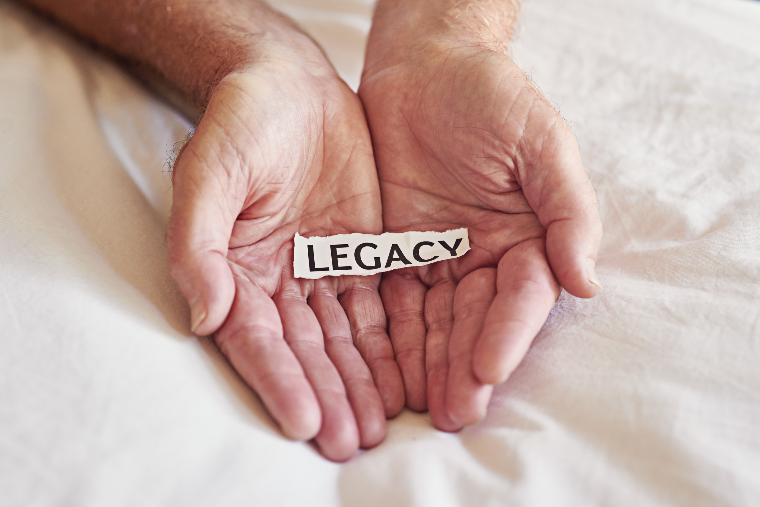 Create a legacy that lasts a lifetime Cropped shot of a person holding a piece of paper with the word legacy written on it