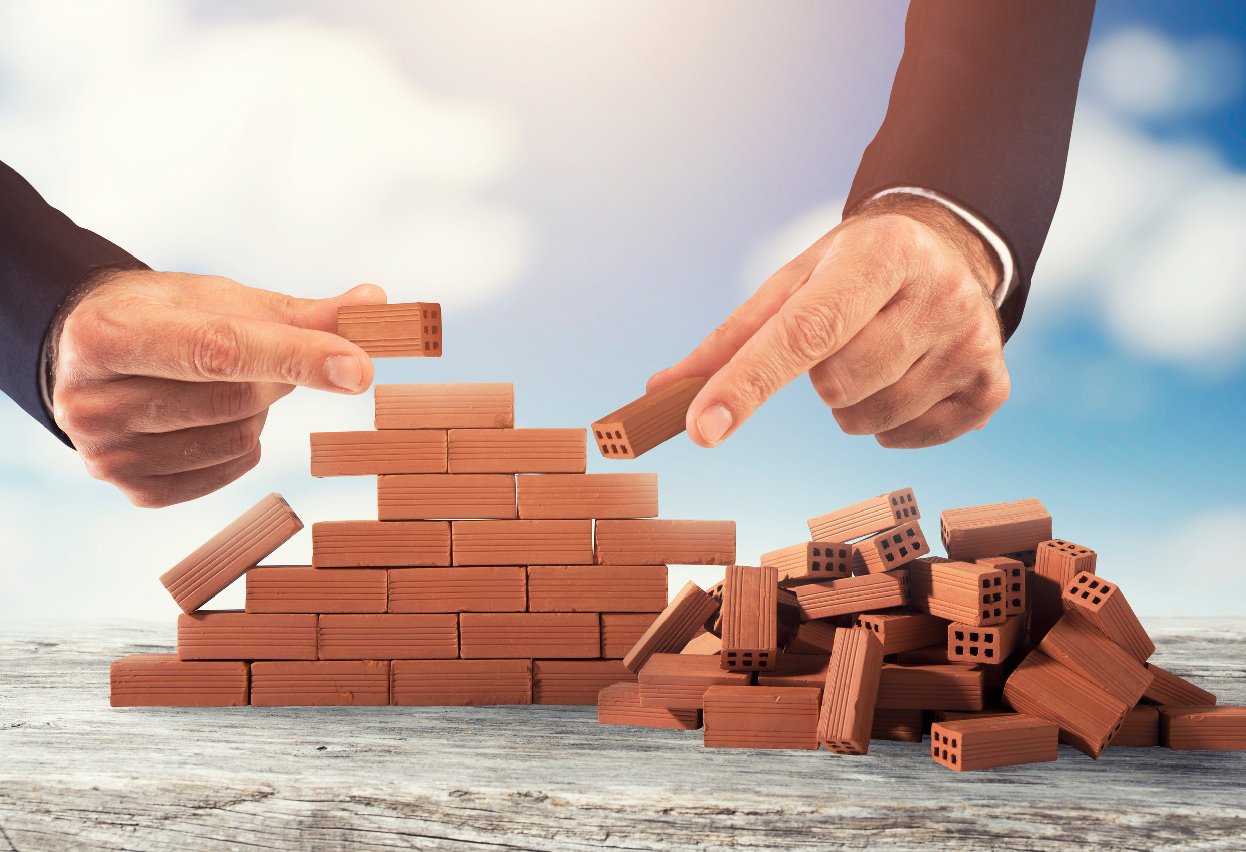 Businessman puts a brick to build a wall Concept of new business, partnership, integration and startup