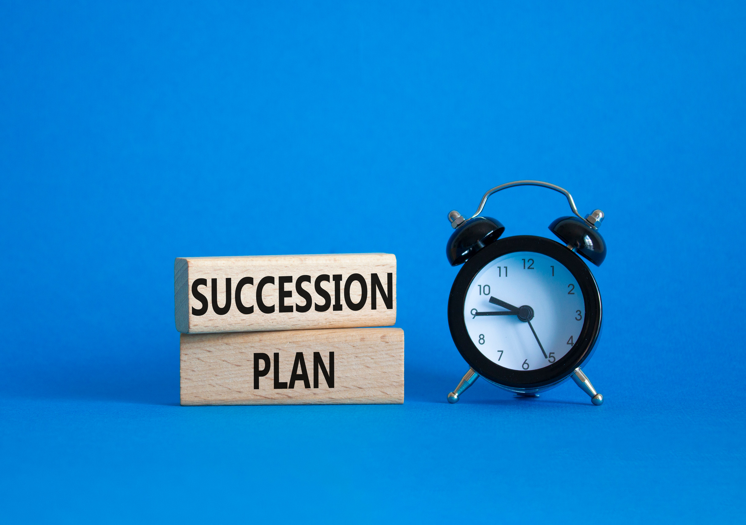 Succession Plan symbol Wooden blocks with words Succession Plan Beautiful blue background with alarm clock Business and Succession Plan concept Copy space